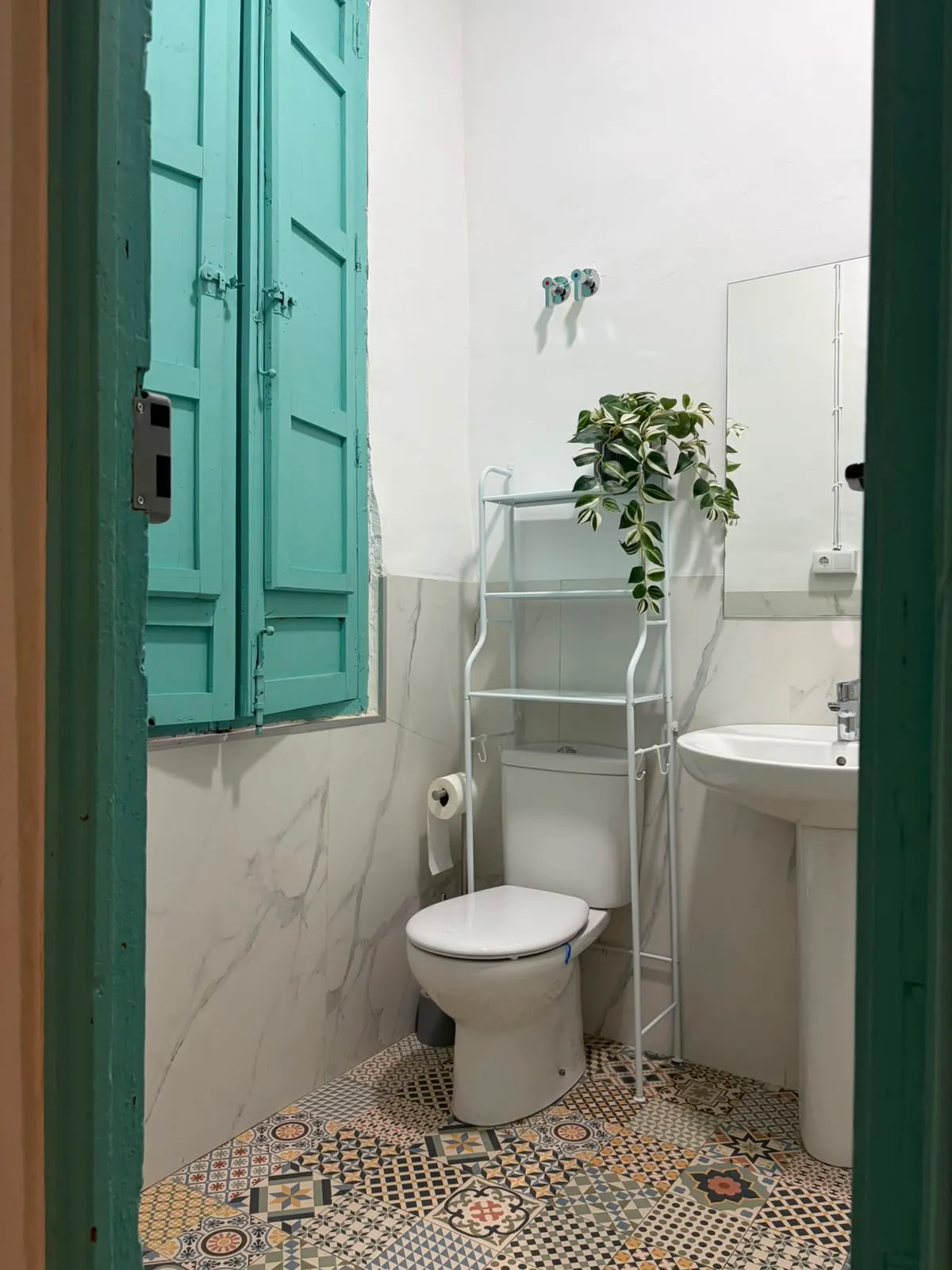 Baño reformado de Greenhome Troneta, con lavabo, espejo y suelo de mosaico hidráulico