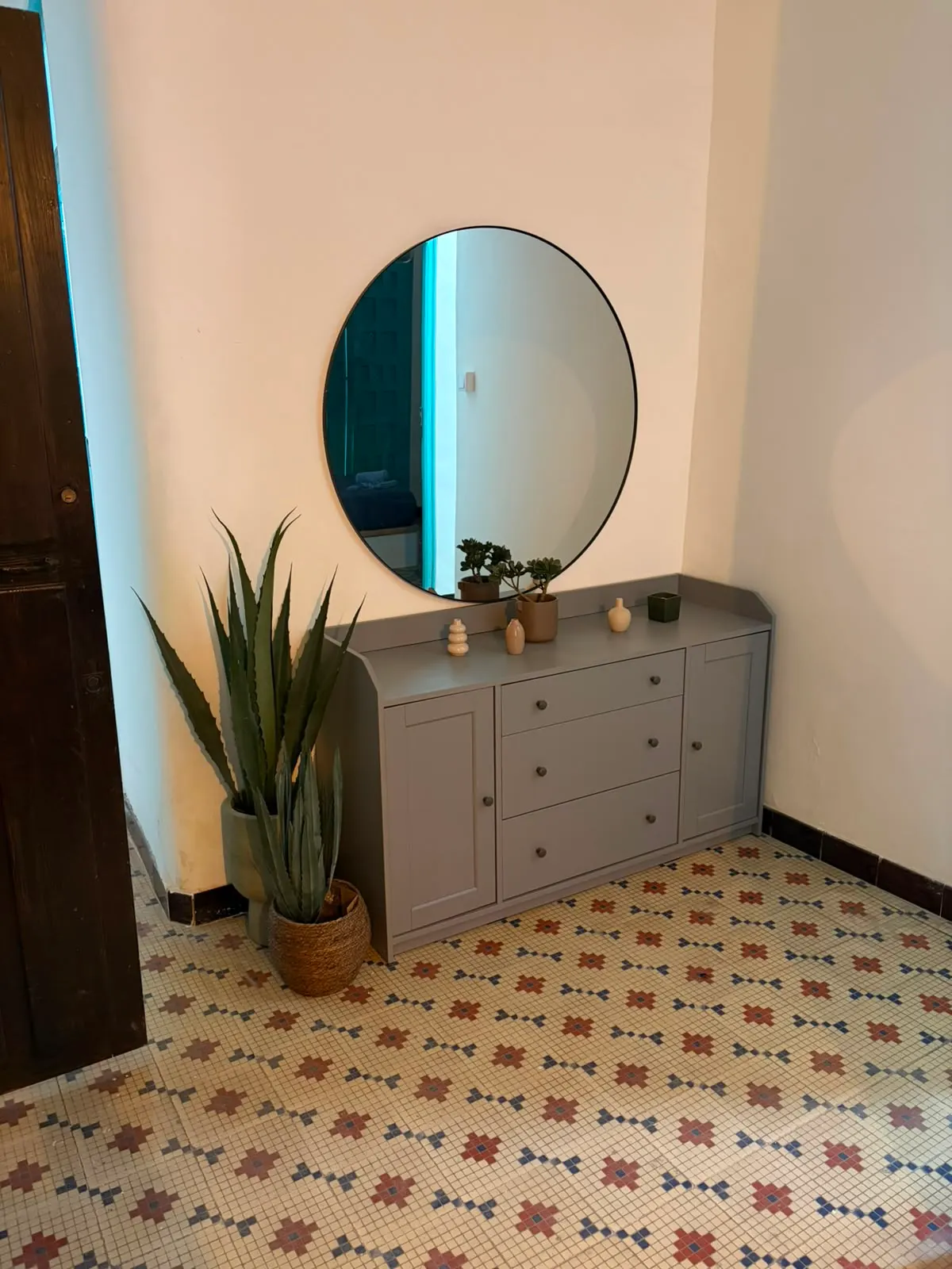 Pasillo de Greenhome Troneta, con suelo de mosaico hidráulico original, espejo y aparador